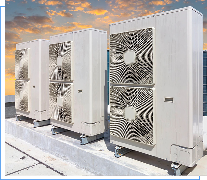 A row of white air conditioners on top of a building.