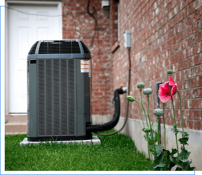 A heat pump is sitting in the grass outside.