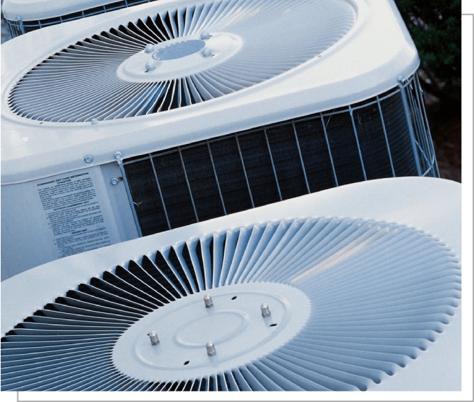 Two air conditioners are sitting outside of a building.