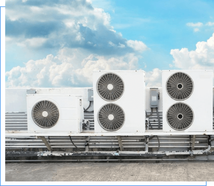 A row of air conditioners on top of a building.